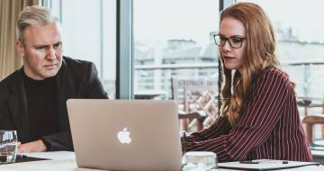 man en vrouw kijken naar appel laptop