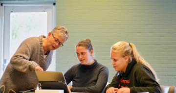 Docent legt theorie uit aan twee studenten 