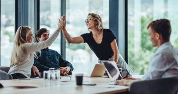 mensen aan tafel geven een high five