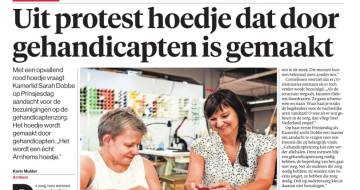 Foto van de Gelderlander krant. Koptekst is Uit protest hoedje dat door gehandicapten is gemaakt. Foto van Sarah dobben met dame